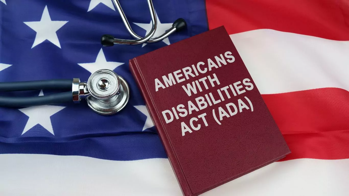 A stethoscope and a book labeled "Americans with Disabilities Act" on top of the U.S. Flag