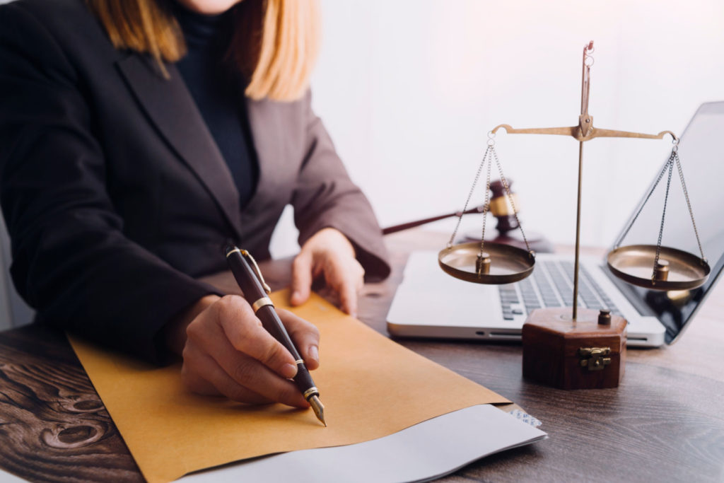 Female lawyer writing a brief for an ADA demand letter.