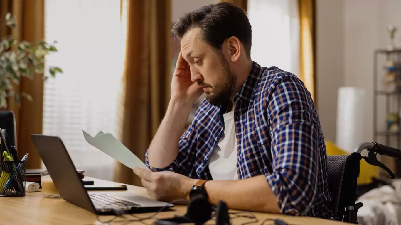 A man on a wheelchair on a laptop