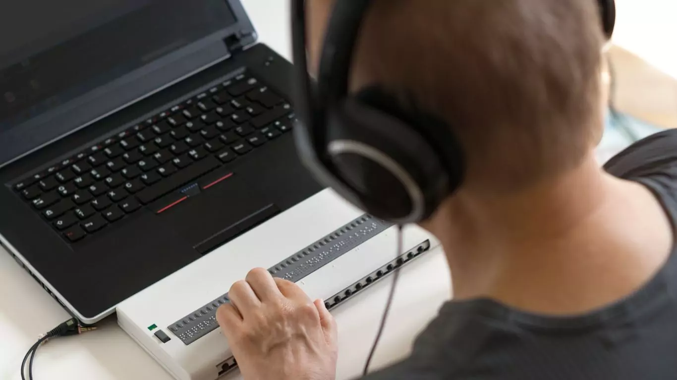 A blind man working on a laptop