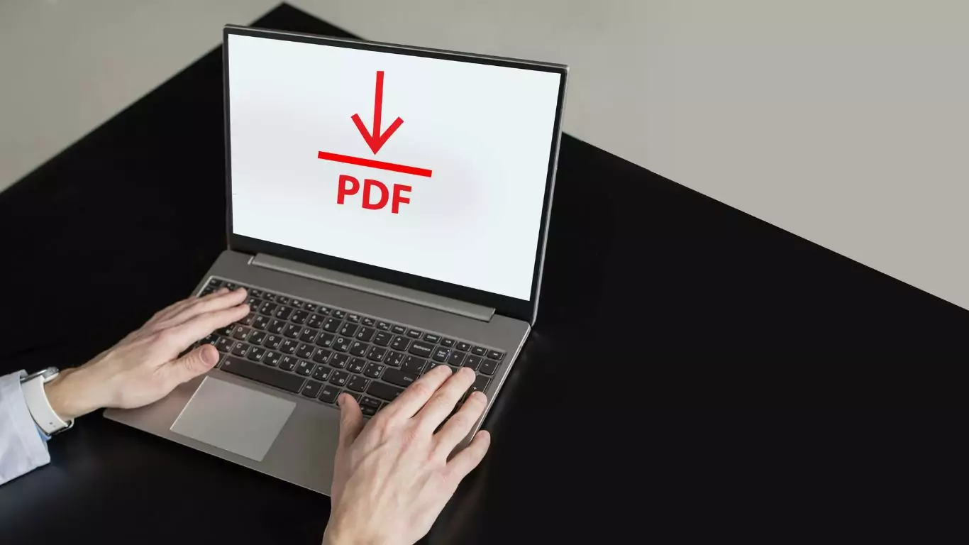 A man uploads a PDF file to a laptop