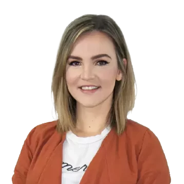 White female with short light blonde hair. Smiling, she is wearing an orange cardigan over a white shirt.