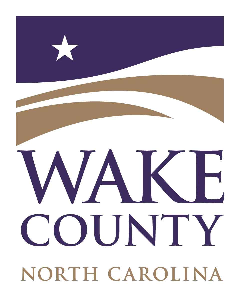 Wake County North Carolina. Government seal featuring white star on purple field with flowing tan curved lines, displaying "WAKE COUNTY" and "NORTH CAROLINA" text in purple and tan letters.